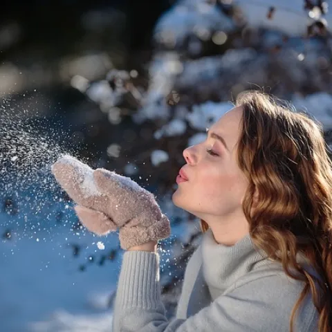 Woman blowing snow